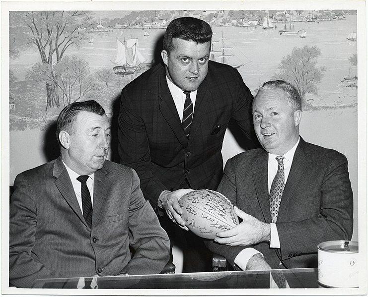 741px-Bob_Dee_of_the_Boston_Patriots_hands_Mayor_John_F._Collins_an_autographed_football_while_another_unidentified_man_watches_%2813561458823%29.jpg
