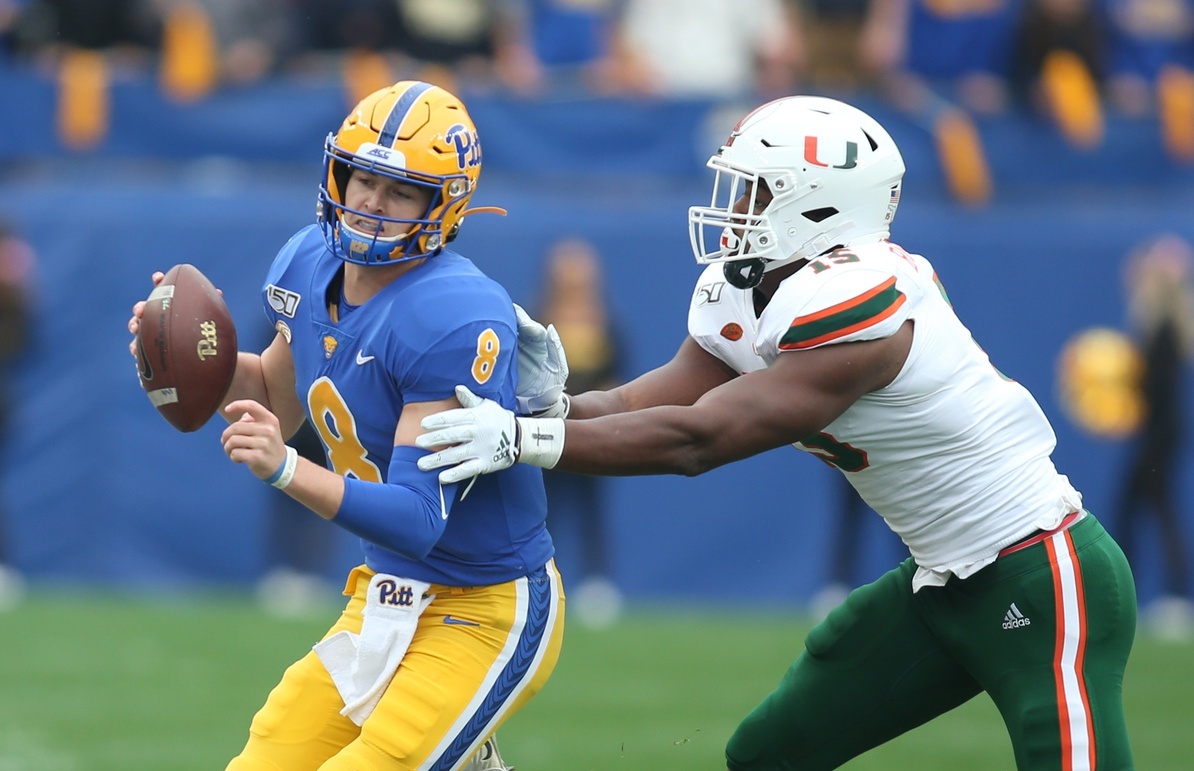 Oct 26, 2019; Pittsburgh, PA, USA;   Pittsburgh Panthers quarterback Kenny Pickett (8) is chased by Miami Hurricanes defensive lineman Gregory Rousseau (15) during the first quarter at Heinz Field. Mandatory Credit: Charles LeClaire-USA TODAY Sports