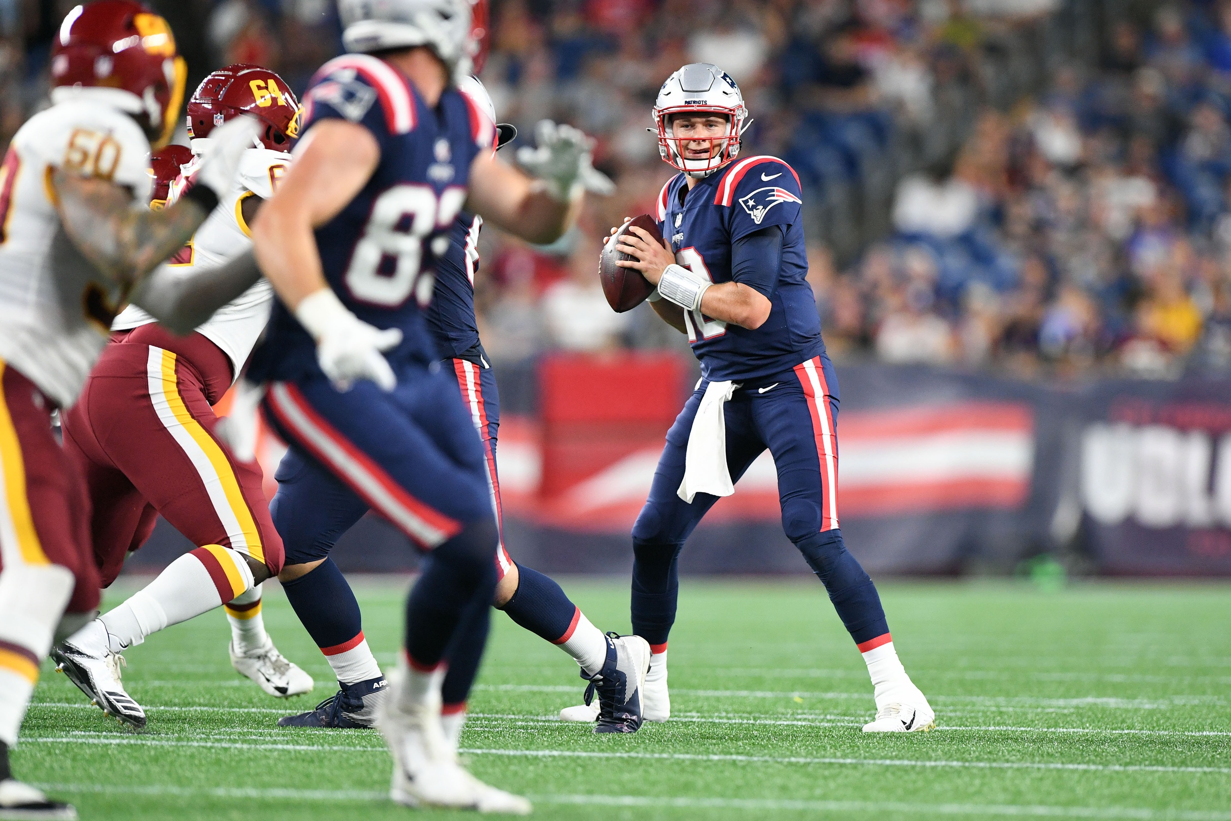 Aug 12, 2021; Foxborough, Massachusetts, USA; New England Patriots quarterback Mac Jones 10) looks to throw against the Washington Football Team during the second half at Gillette Stadium. Mandatory Credit: Brian Fluharty-USA TODAY Sports