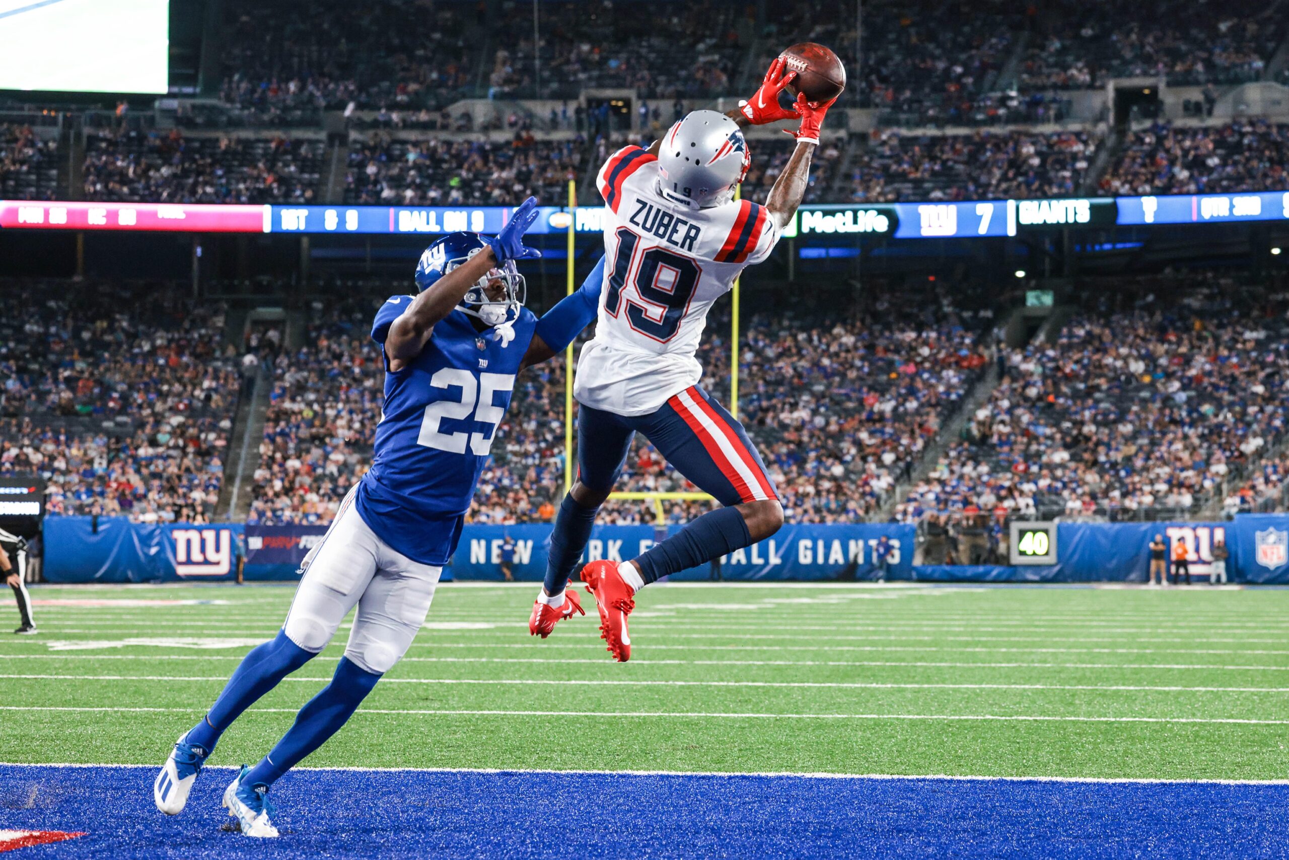 Aug 29, 2021; East Rutherford, New Jersey, USA; New England Patriots wide receiver Isaiah Zuber (19) can not complete a reception in front of New York Giants cornerback Rodarius Williams (25) during the second half at MetLife Stadium. Mandatory Credit: Vincent Carchietta-USA TODAY Sports
