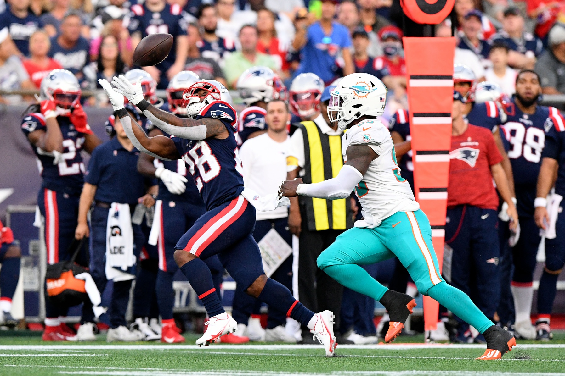 Sep 12, 2021; Foxborough, Massachusetts, USA; New England Patriots running back James White (28) makes a catch in front of Miami Dolphins outside linebacker Jerome Baker (55) during the second half at Gillette Stadium. Mandatory Credit: Brian Fluharty-USA TODAY Sports