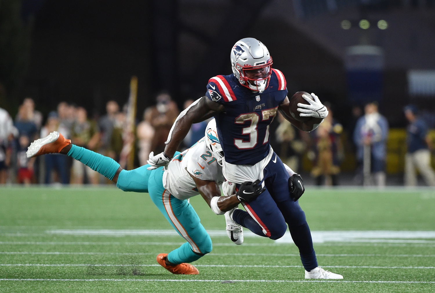 Sep 12, 2021; Foxborough, Massachusetts, USA;  New England Patriots running back Damien Harris (37) gets tackled by Miami Dolphins cornerback Eric Rowe (21) during the second half at Gillette Stadium. Mandatory Credit: Bob DeChiara-USA TODAY Sports