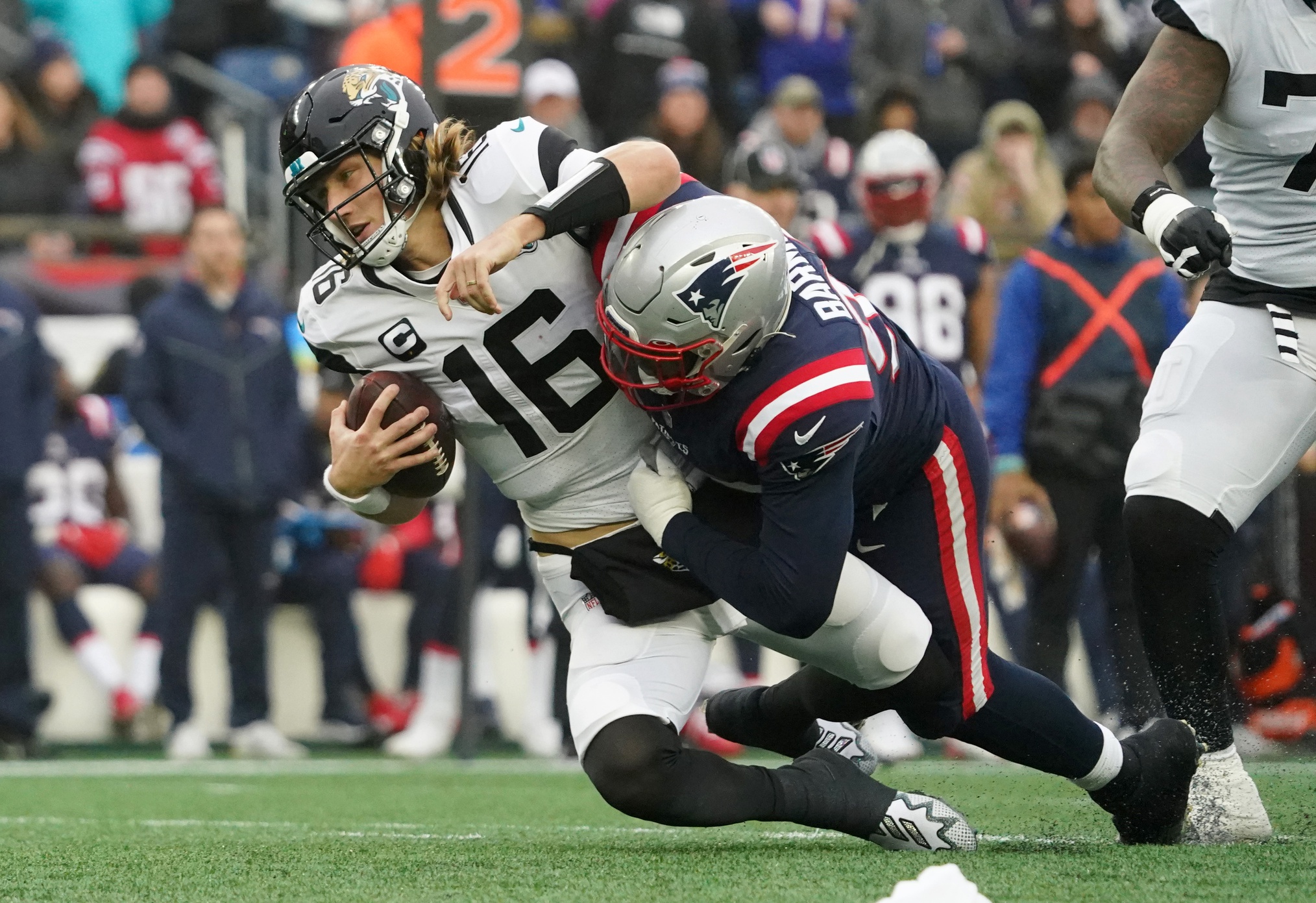 Jan 2, 2022; Foxborough, Massachusetts, Jacksonville Jaguars quarterback Trevor Lawrence (16) is sacked by New England Patriots defensive end Christian Barmore (90) in the second quarter at Gillette Stadium. Mandatory Credit: David Butler II-USA TODAY Sports