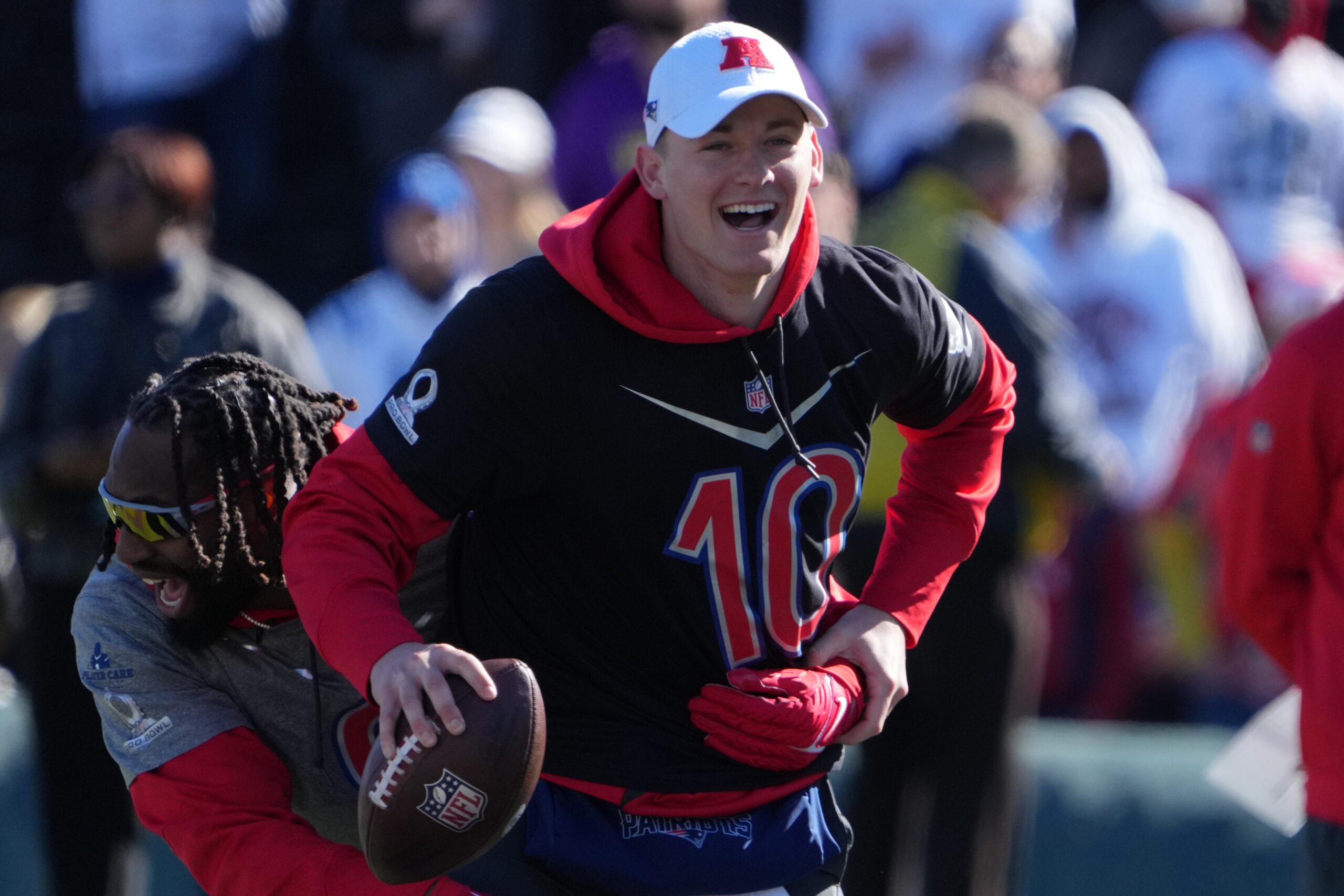 Feb 4, 2022; Las Vegas, NV, USA; New England Patriots quarterback Mac Jones (10) interacts with linebacker Matthew Judon (9) during AFC practice at the Las Vegas Ballpark. Mandatory Credit: Kirby Lee-USA TODAY Sports