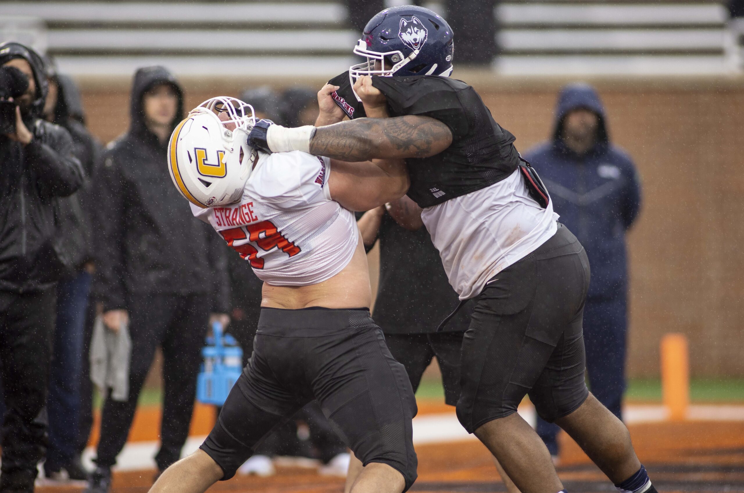 Feb 2, 2022; Mobile, AL, USA;  National offensive lineman Cole Strange of Tennessee-Chattanooga (69) spars with National defensive lineman Travis Jones of Connecticut (57) during National practice for the 2022 Senior Bowl in Mobile, AL, USA.  
Mandatory Credit: Vasha Hunt-USA TODAY Sports