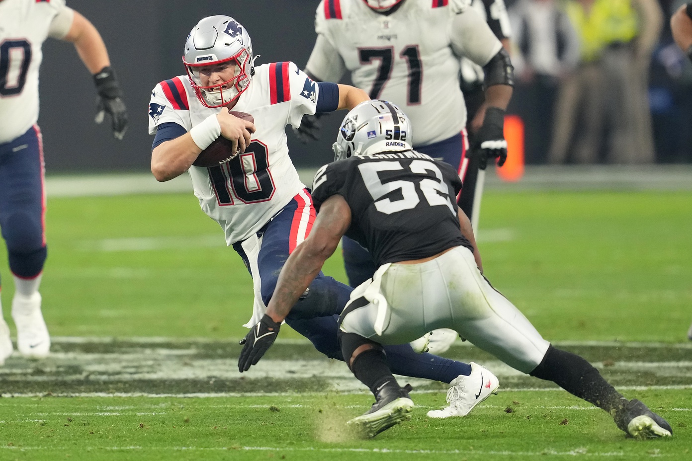 Dec 18, 2022; Paradise, Nevada, USA; New England Patriots quarterback Mac Jones (10) is flushed from the pocket by the Las Vegas Raiders during the second half at Allegiant Stadium. Mandatory Credit: Stephen R. Sylvanie-USA TODAY Sports