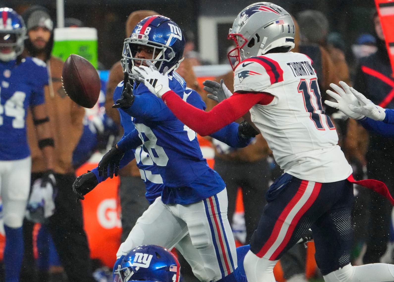Nov 26, 2023; East Rutherford, New Jersey, USA; New York Giants cornerback Cor'Dale Flott (28) and New England Patriots wide receiver Tyquan Thornton (11) fight for the ball in the 2nd half at MetLife Stadium. Mandatory Credit: Robert Deutsch-USA TODAY Sports