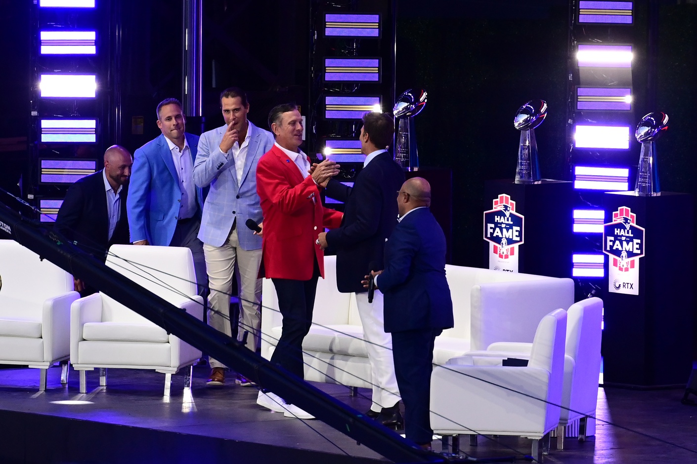 Jun 12, 2024; Foxborough, MA, USA; Retired quarterback Drew Bledsoe (red) shakes hands with Tom Brady during the New England Patriots Hall of Fame induction Ceremony for Brady at Gillette Stadium.  Mandatory Credit: Eric Canha-USA TODAY Sports