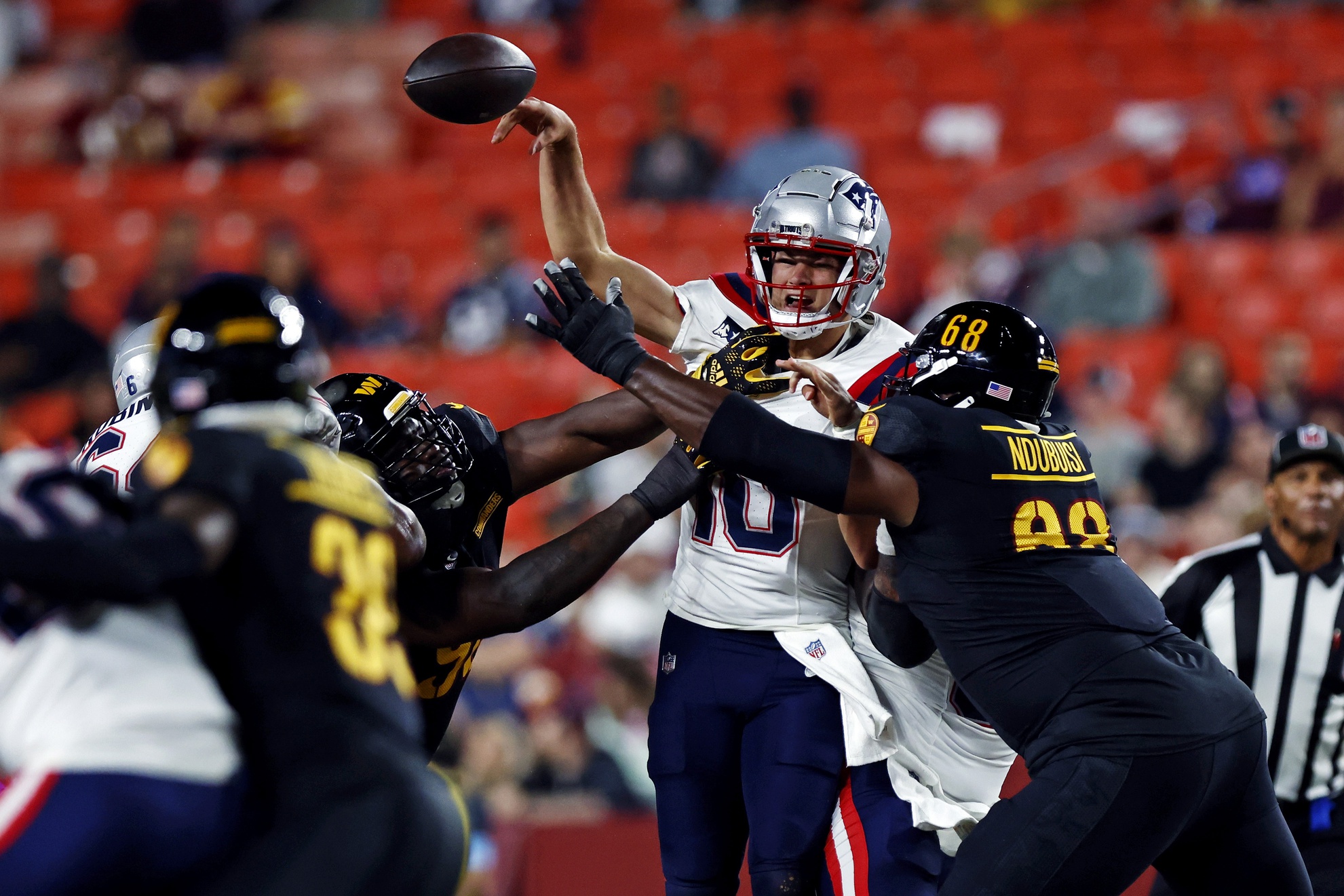 Aug 25, 2024; Landover, Maryland, USA; New England Patriots quarterback Drake Maye (10) is pressured by Washington Commanders defensive tackle Haggai Ndubuisi (68) and defensive tackle Daron Payne (94) during the first quarter during a preseason game at Commanders Field. Mandatory Credit: Peter Casey-USA TODAY Sports