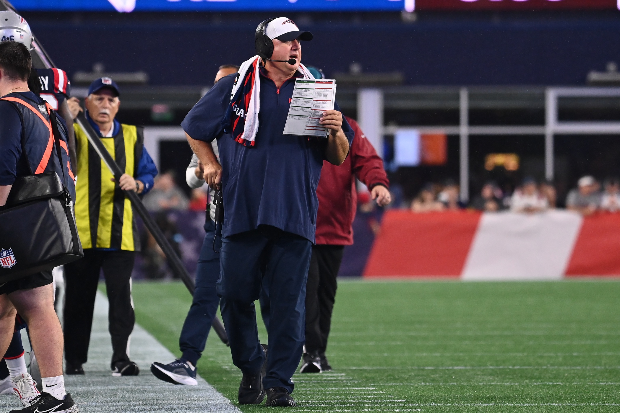 August 8, 2024; Foxborough, MA, USA;  New England Patriots offensive coordinator Alex Van Pelt works on the sideline during the first half against the Carolina Panthers at Gillette Stadium. Mandatory Credit: Eric Canha-USA TODAY Sports