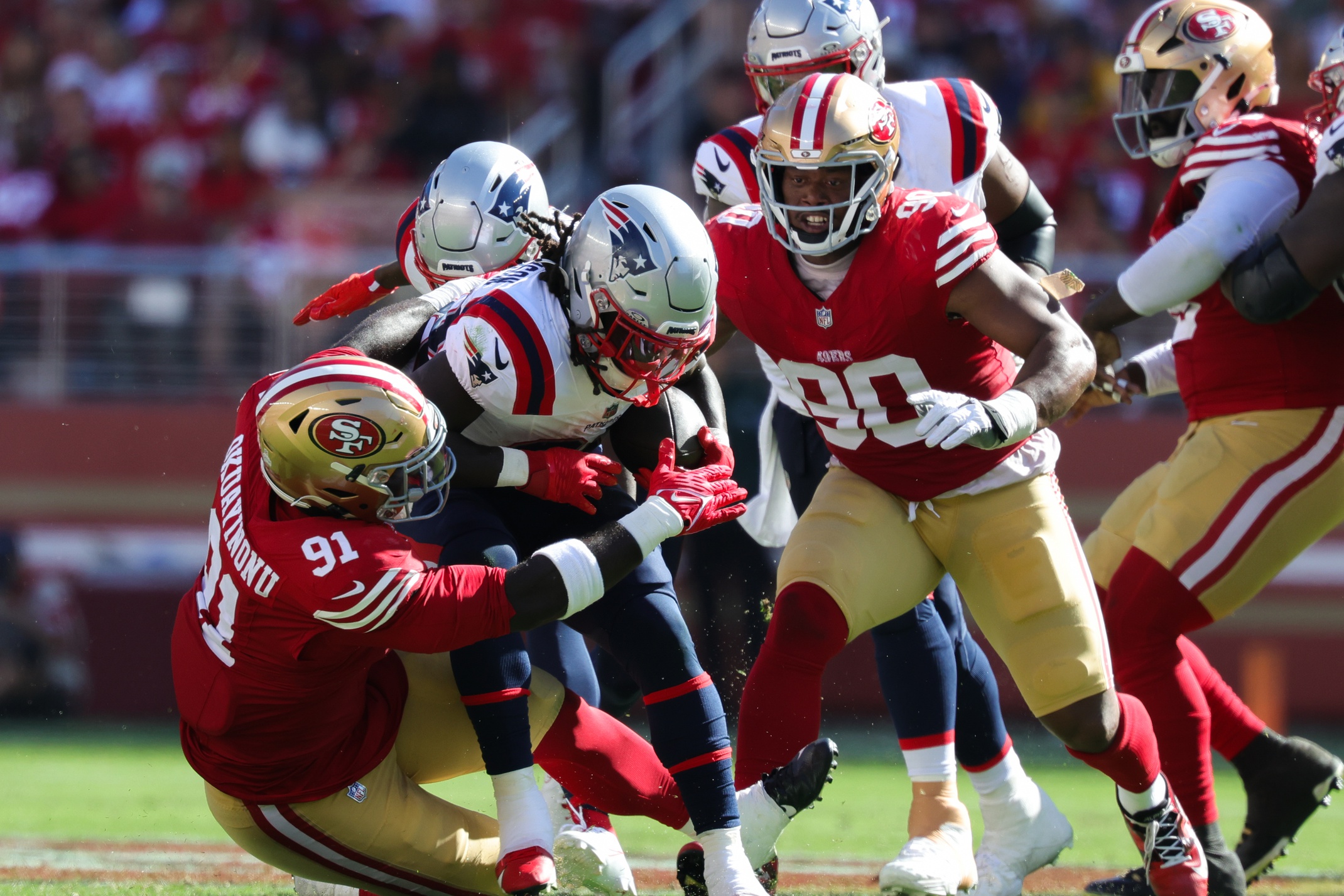 Sep 29, 2024; Santa Clara, California, USA; New England Patriots running back Rhamondre Stevenson (38) is tackled by San Francisco 49ers defensive tackle Sam Okuayinonu (91) during the fourth quarter at Levi's Stadium. Mandatory Credit: Sergio Estrada-Imagn Images