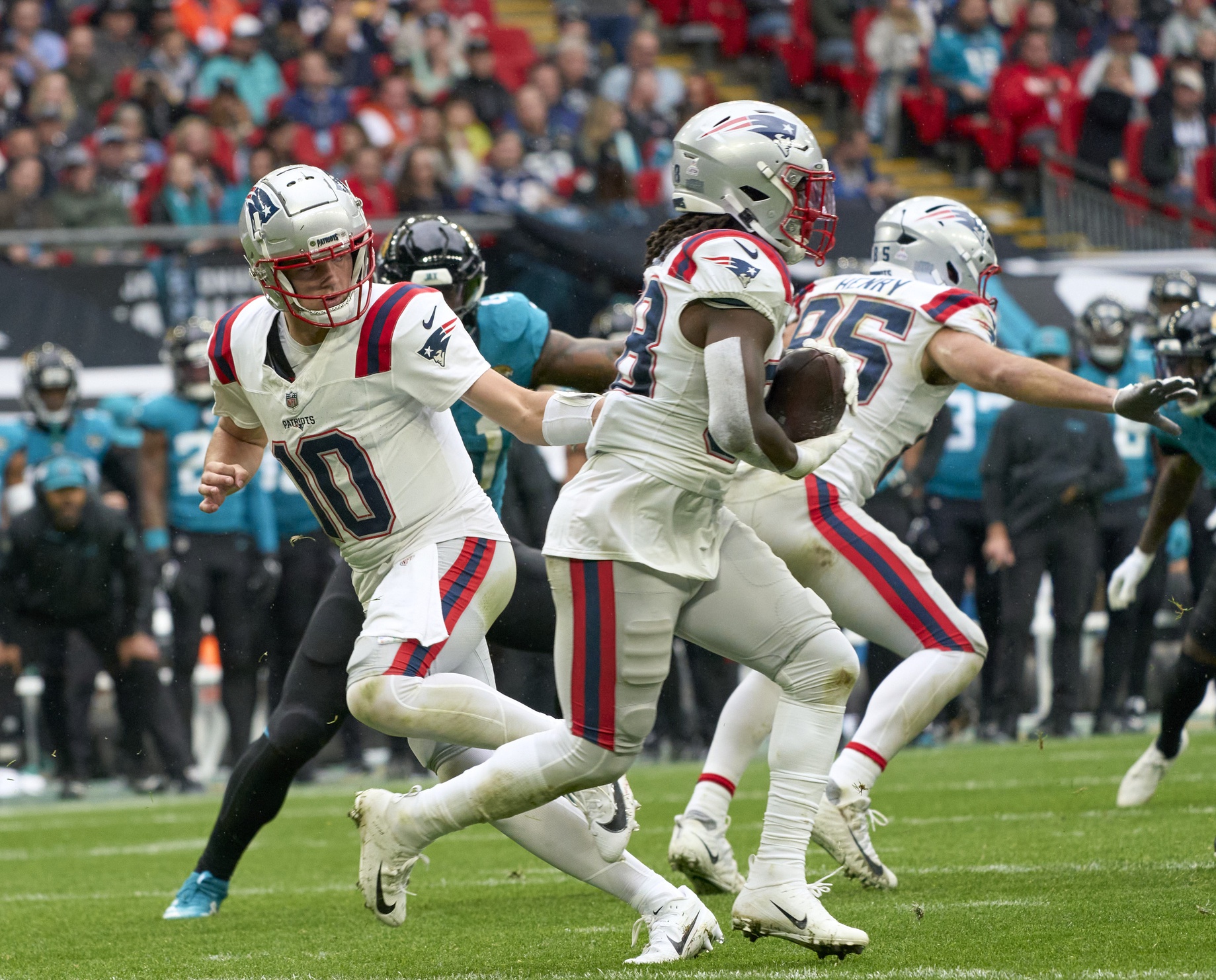 Oct 20, 2024; London, United Kingdom; New England Patriots quarterback Drake Maye (10) passes to New England Patriots running back Rhamondre Stevenson (38) in the first half during an NFL International Series game at Wembley Stadium. Mandatory Credit: Peter van den Berg-Imagn Images
