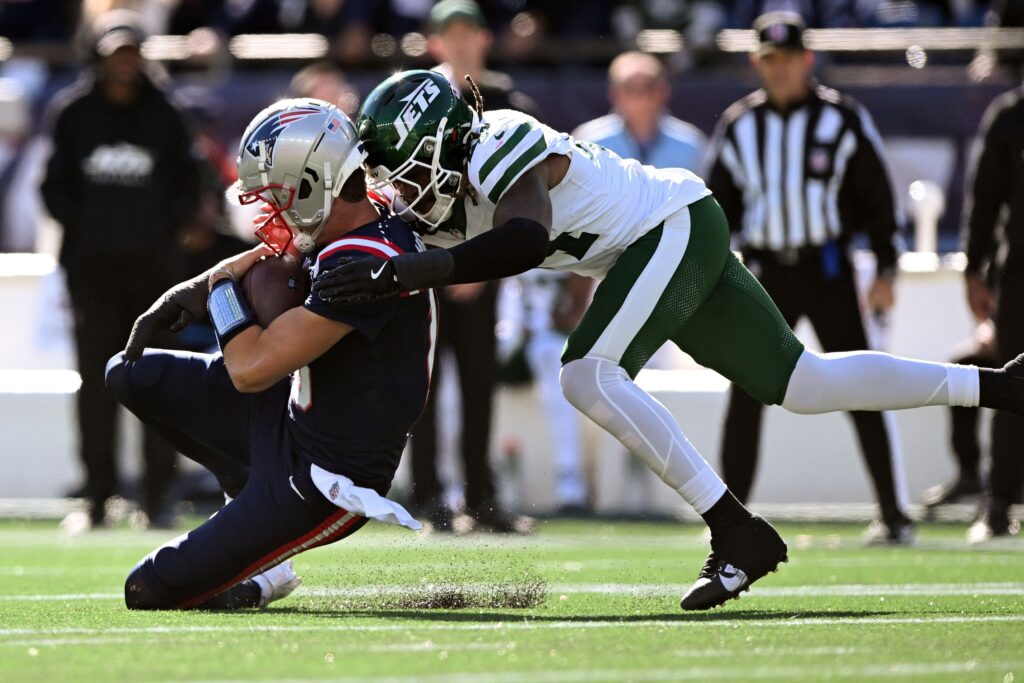Oct 27, 2024; Foxborough, Massachusetts, USA; New England Patriots quarterback Drake Maye (10) is tackled by New York Jets linebacker Jamien Sherwood (44) during the first half at Gillette Stadium. Mandatory Credit: Brian Fluharty-Imagn Images