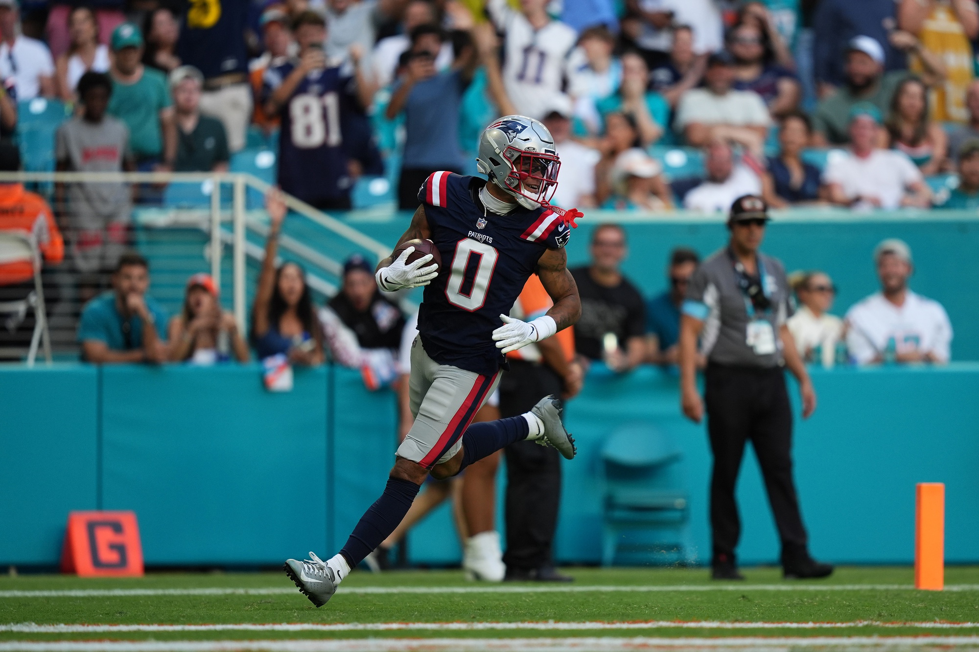Nov 24, 2024; Miami Gardens, Florida, USA; New England Patriots cornerback Christian Gonzalez (0) runs the ball for a touchdown after recovering a fumble against the Miami Dolphins during the second half at Hard Rock Stadium. Mandatory Credit: Jasen Vinlove-Imagn Images