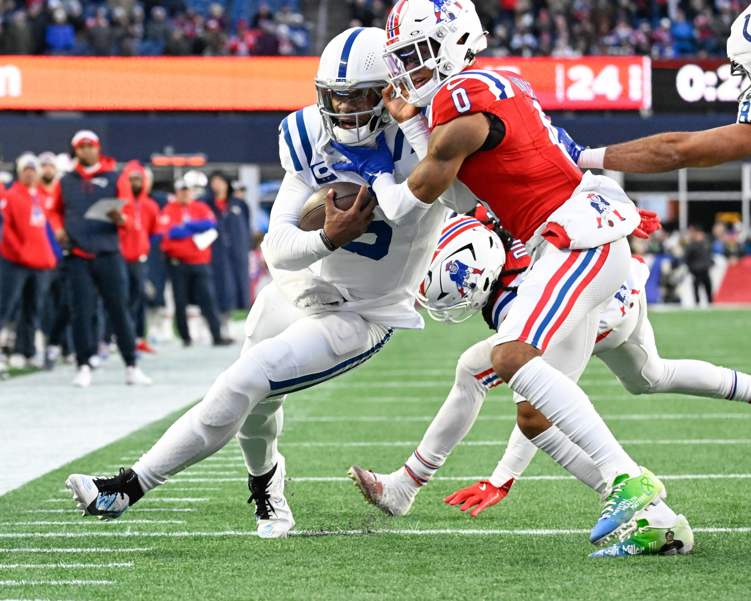 Dec 1, 2024; Foxborough, Massachusetts, USA; New England Patriots cornerback Christian Gonzalez (0) tackles Indianapolis Colts quarterback Anthony Richardson (5) short of the goal line during the second half at Gillette Stadium. Mandatory Credit: Eric Canha-Imagn Images
