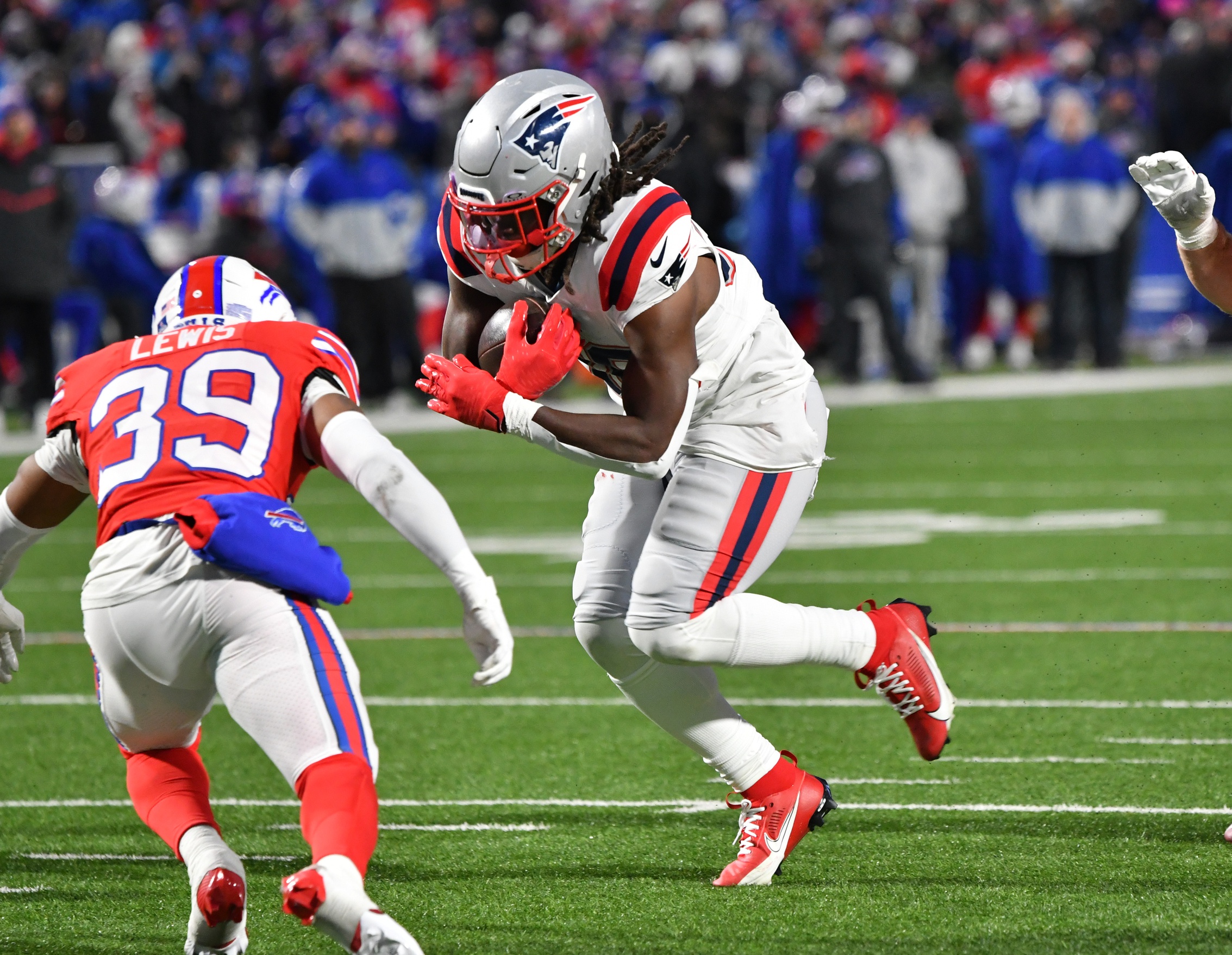 Dec 22, 2024; Orchard Park, New York, USA; New England Patriots running back Rhamondre Stevenson (38) breaks a tackle by Buffalo Bills cornerback Cam Lewis (39) to score a touchdown in the second quarter at Highmark Stadium. Mandatory Credit: Mark Konezny-Imagn Images