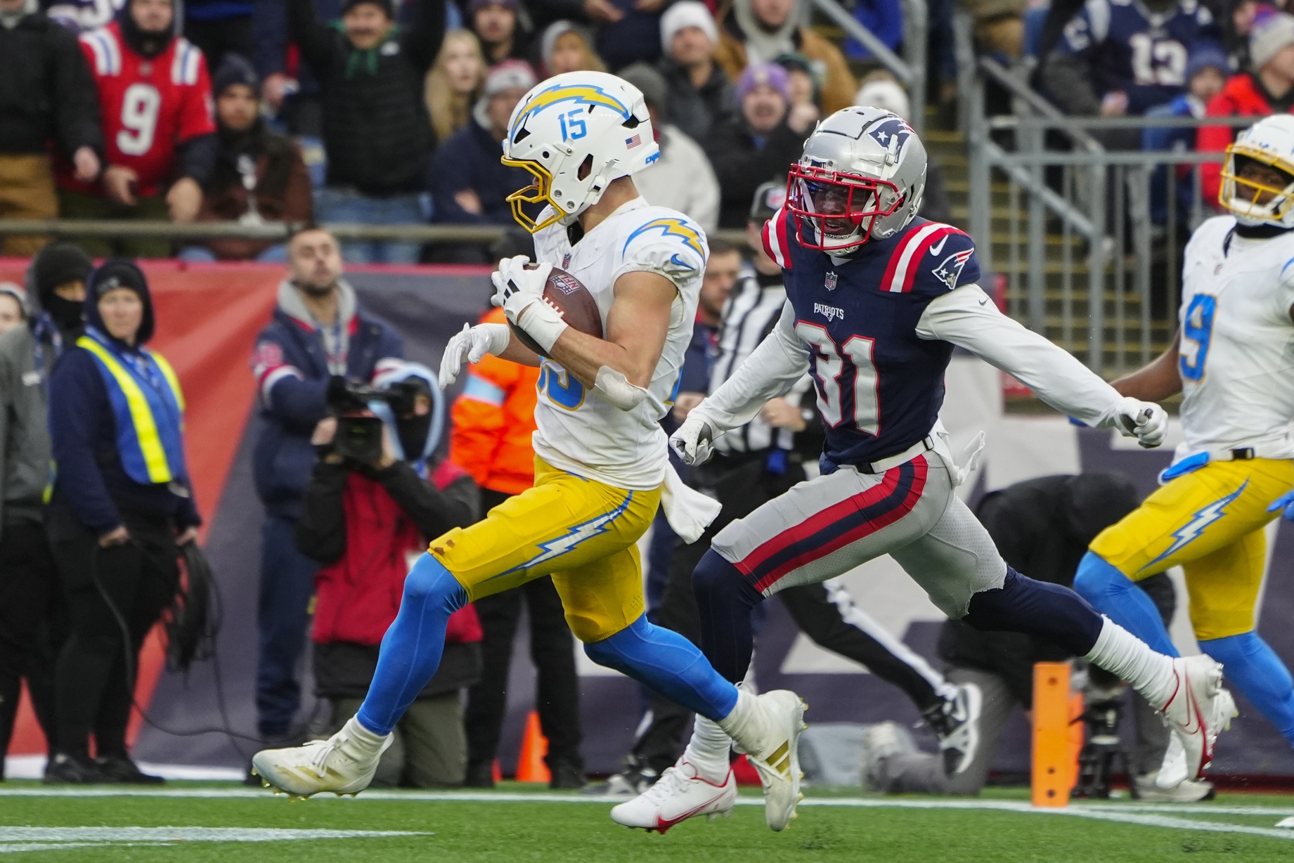 Dec 28, 2024; Foxborough, Massachusetts, USA; Los Angeles Chargers wide receiver Ladd McConkey (15) runs for a touchdown after a catch against New England Patriots cornerback Jonathan Jones (31) during the second half at Gillette Stadium. Mandatory Credit: Gregory Fisher-Imagn Images