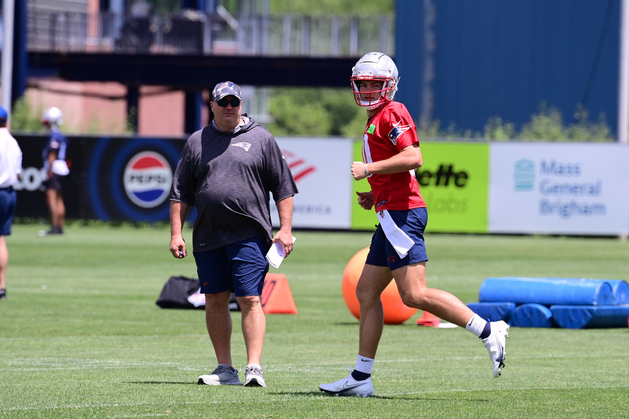 Jun 10, 2024; Foxborough, MA, USA; New England Patriots quarterback Drake Maye (10) works out as offensive coordinator Alex Van Pelt watches at minicamp at Gillette Stadium. Mandatory Credit: Eric Canha-USA TODAY Sports