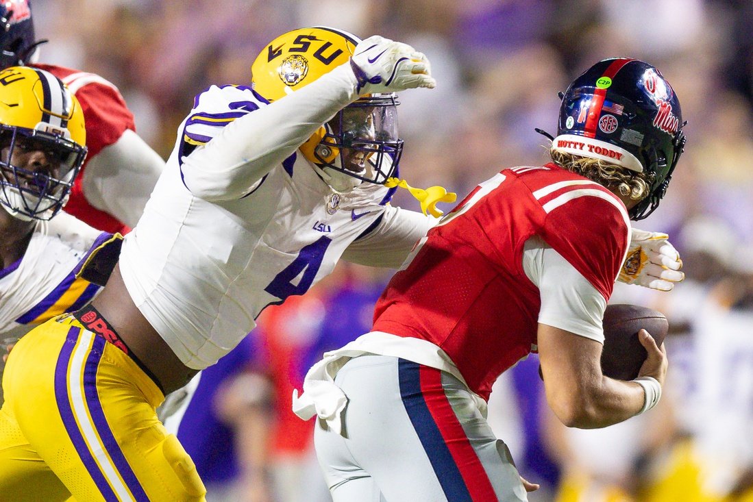 Oct 12, 2024; Baton Rouge, Louisiana, USA;  LSU Tigers defensive end Bradyn Swinson (4) sacks Mississippi Rebels quarterback Jaxson Dart (2) during the second half at Tiger Stadium. Mandatory Credit: Stephen Lew-Imagn Images