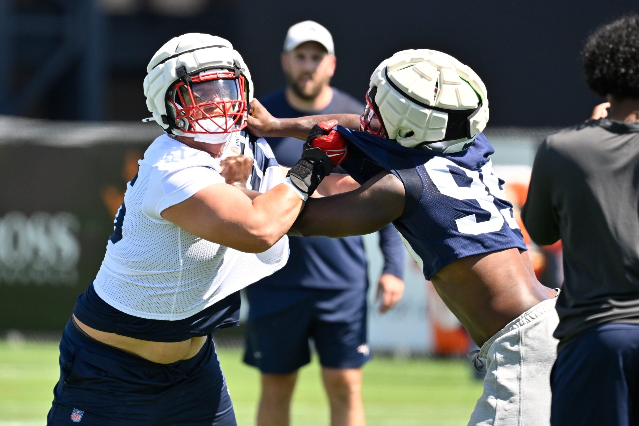Jul 23, 2025; Foxborough, MA, USA; New England Patriots offensive tackle Will Campbell (66) and defensive end Keion White (99) work on a drill during training camp at Gillette Stadium. Mandatory Credit: Eric Canha-Imagn Images