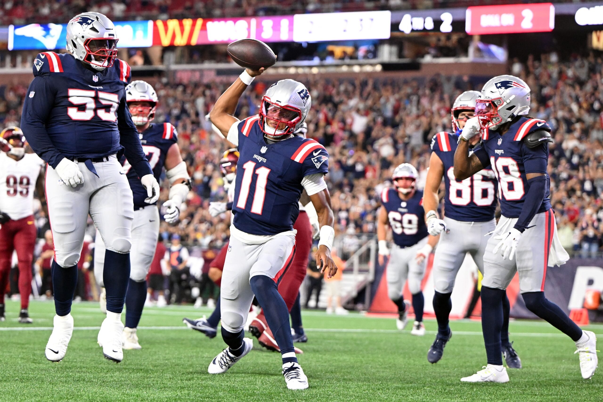 Aug 8, 2025; Foxborough, Massachusetts, USA; New England Patriots quarterback Joshua Dobbs (11) spikes the ball after scoring a touchdown against the Washington Commanders during the first half at Gillette Stadium. Mandatory Credit: Brian Fluharty-Imagn Images