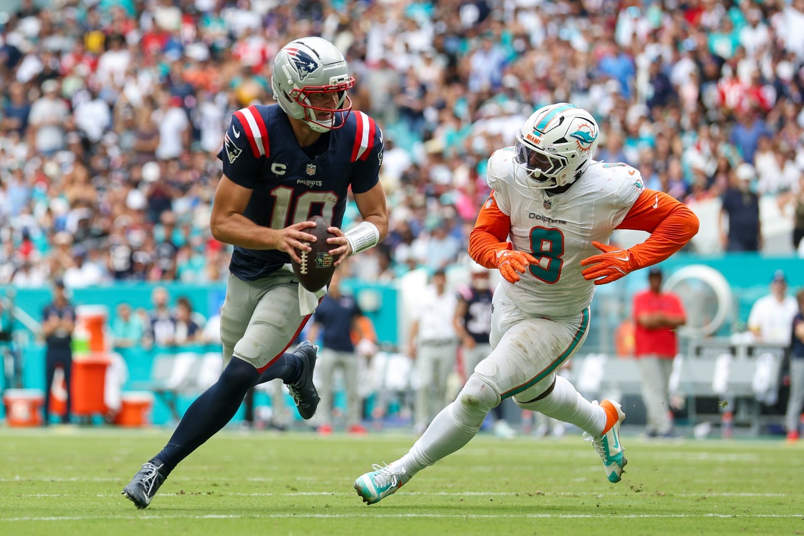 Sep 14, 2025; Miami Gardens, Florida, USA; New England Patriots quarterback Drake Maye (10) runs the ball chased by Miami Dolphins linebacker Matthew Judon (8) in the third quarter at Hard Rock Stadium. Mandatory Credit: Nathan Ray Seebeck-Imagn Images