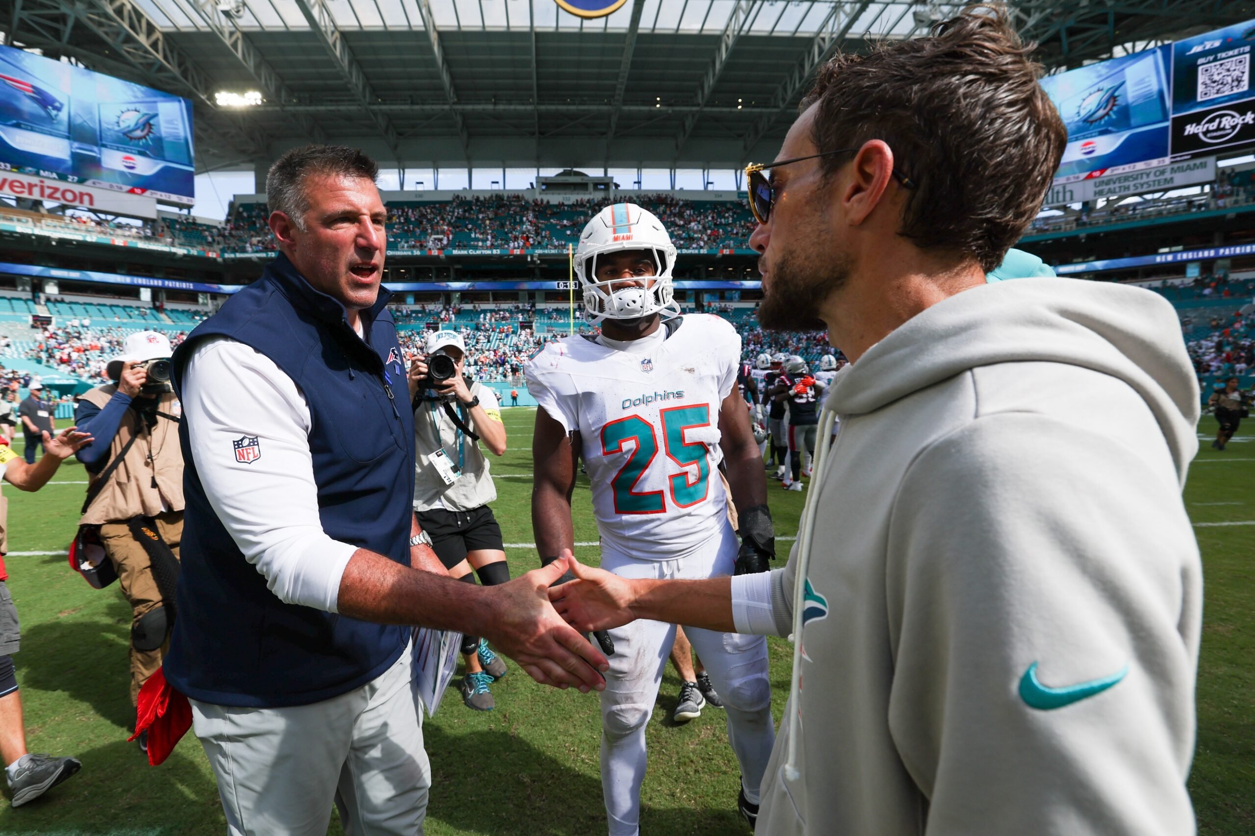 Sep 14, 2025; Miami Gardens, Florida, USA; New England Patriots head coach Mike Vrabel greets Miami Dolphins head coach Mike McDaniel after a game at Hard Rock Stadium. Mandatory Credit: Nathan Ray Seebeck-Imagn Images