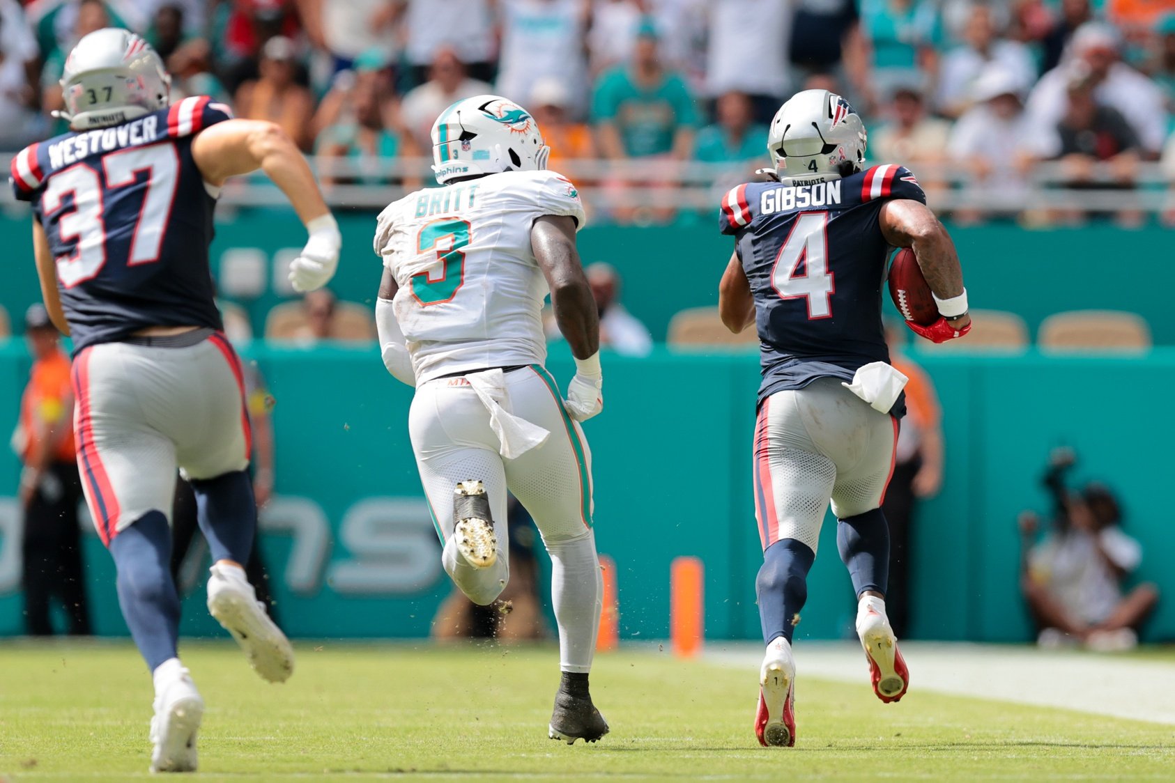 Sep 14, 2025; Miami Gardens, Florida, USA; New England Patriots running back Antonio Gibson (4) carries the football for a kickoff return against the Miami Dolphins during the fourth quarter at Hard Rock Stadium. Mandatory Credit: Sam Navarro-Imagn Images