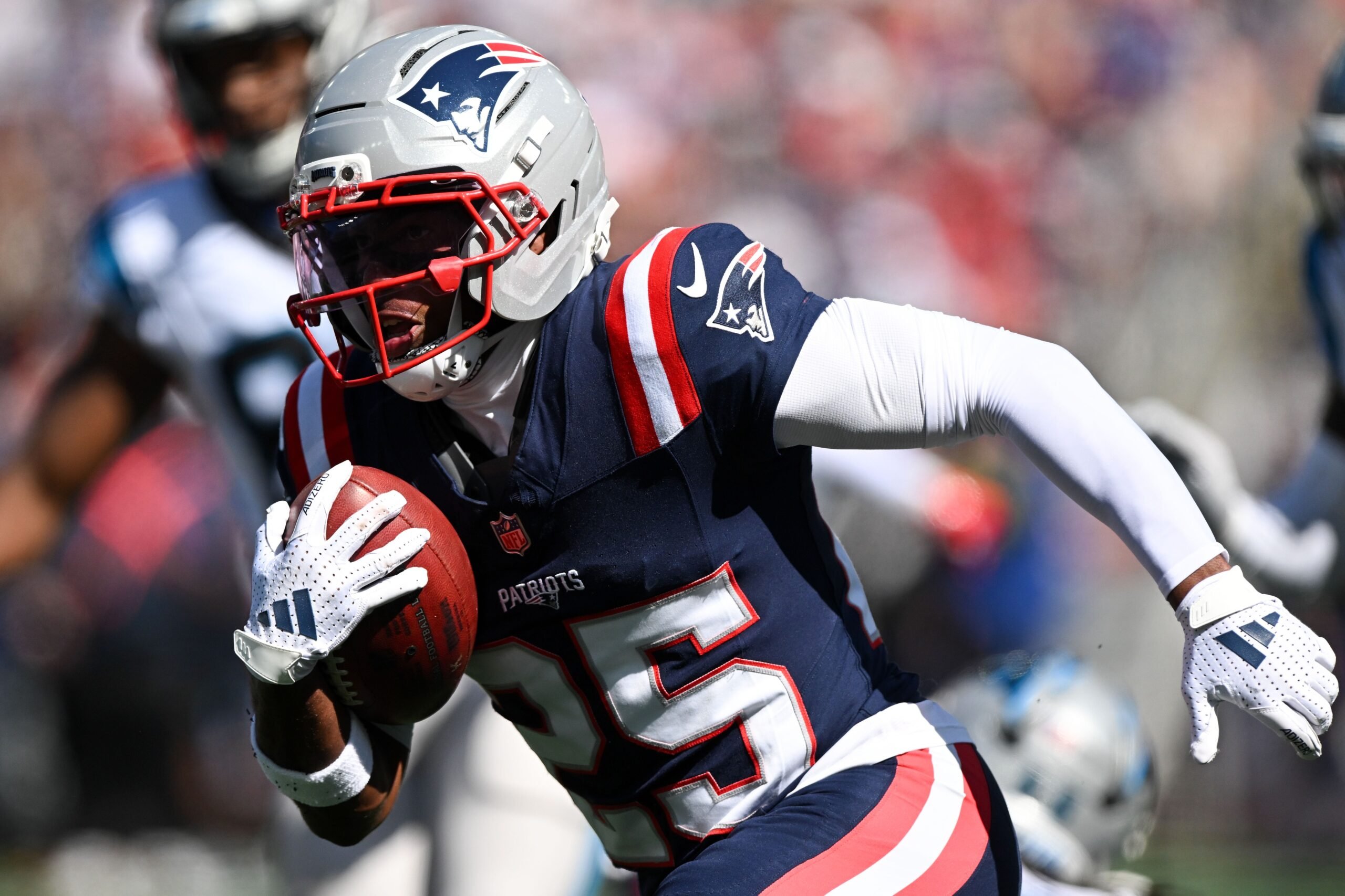 Sep 28, 2025; Foxborough, Massachusetts, USA; New England Patriots cornerback Marcus Jones (25) returns a punt for a touchdown against the Carolina Panthers during the first half at Gillette Stadium. Mandatory Credit: Brian Fluharty-Imagn Images
