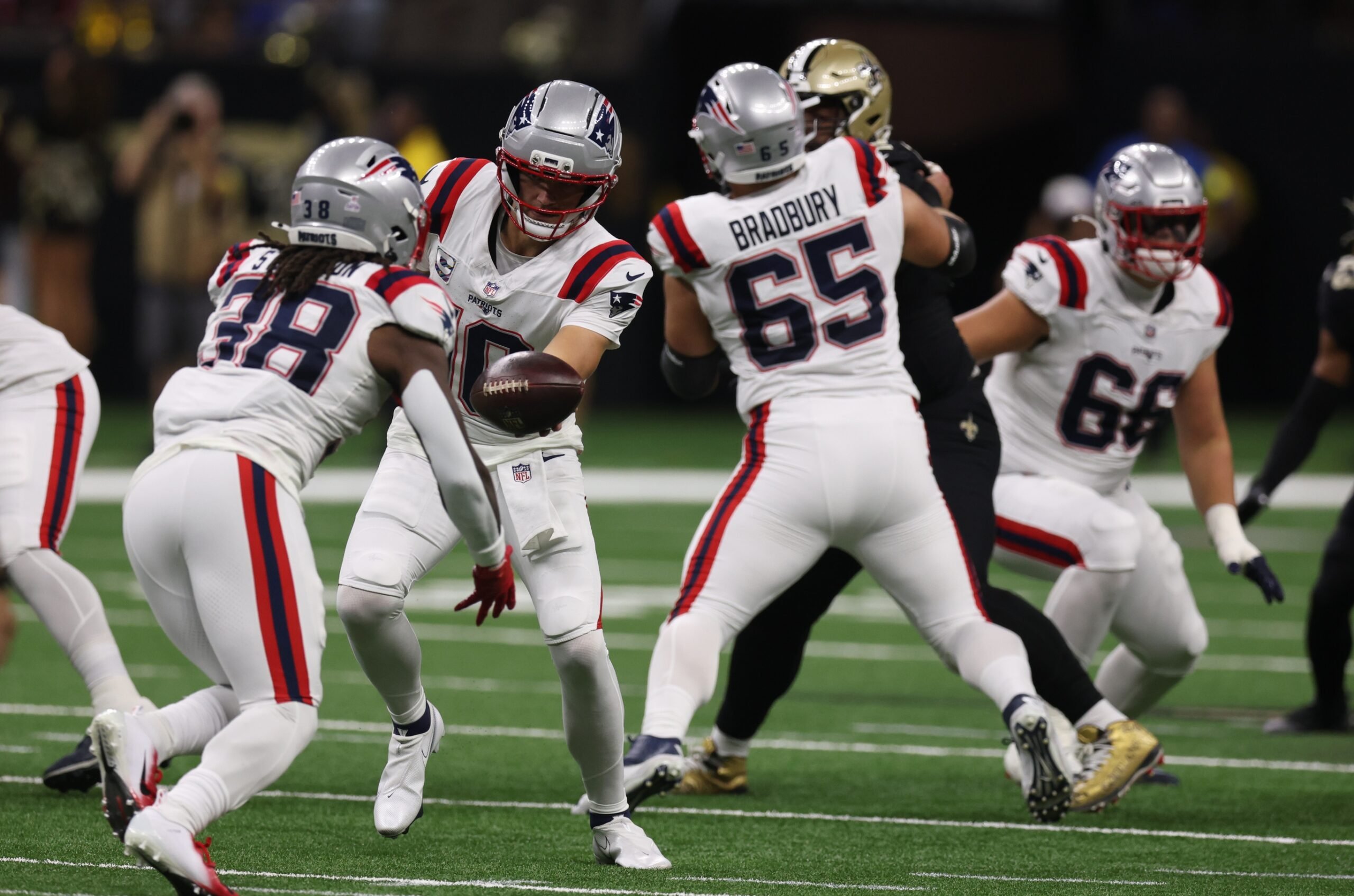 Oct 12, 2025; New Orleans, Louisiana, USA; New England Patriots quarterback Drake Maye (10) hands the ball off to New England Patriots running back Rhamondre Stevenson (38) during the first quarter against the New Orleans Saints at Caesars Superdome. Mandatory Credit: Stephen Lew-Imagn Images