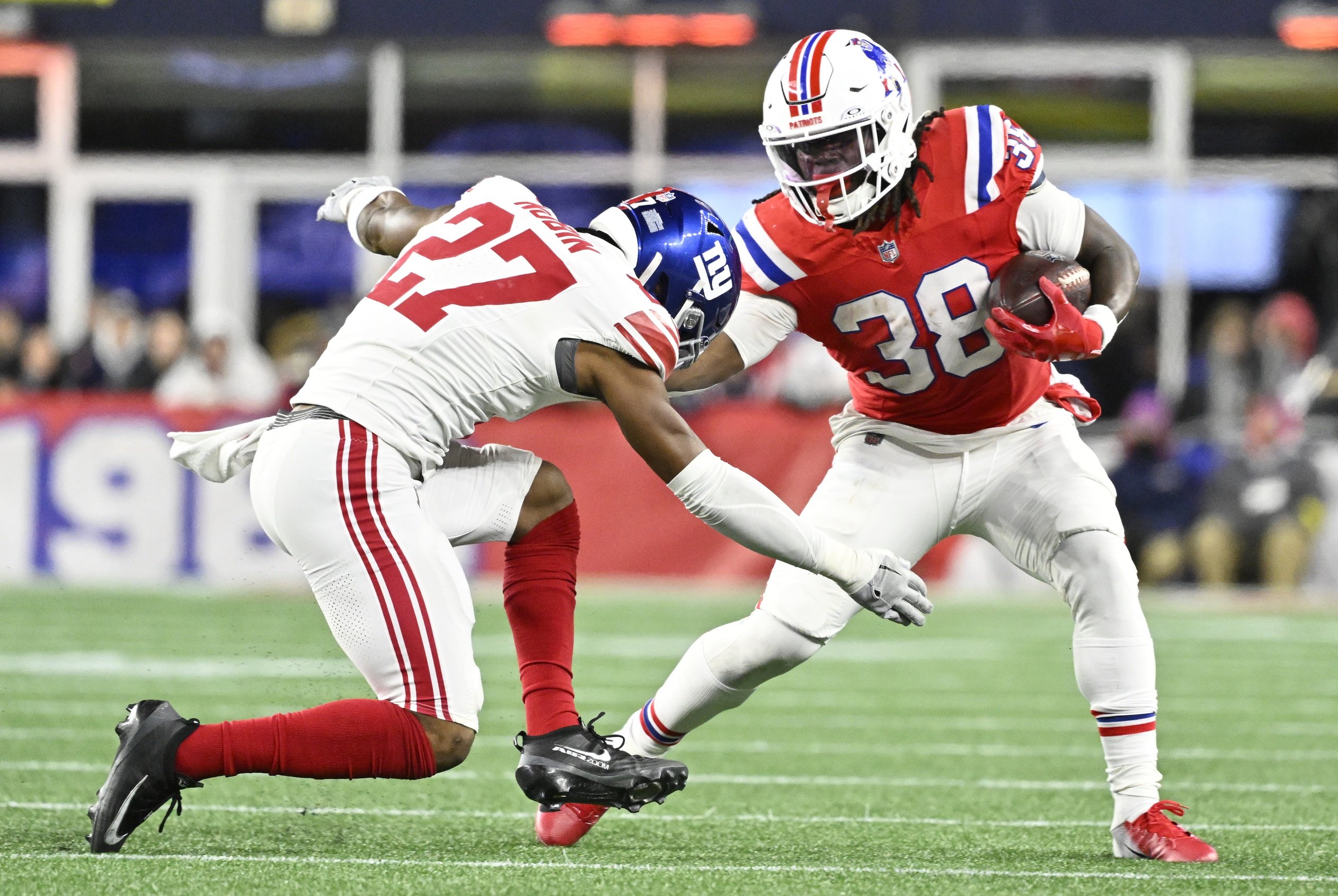 Dec 1, 2025; Foxborough, Massachusetts, USA; New England Patriots running back Rhamondre Stevenson (38) runs the ball against New York Giants safety Tyler Nubin (27) during the fourth quarter at Gillette Stadium. Mandatory Credit: Eric Canha-Imagn Images