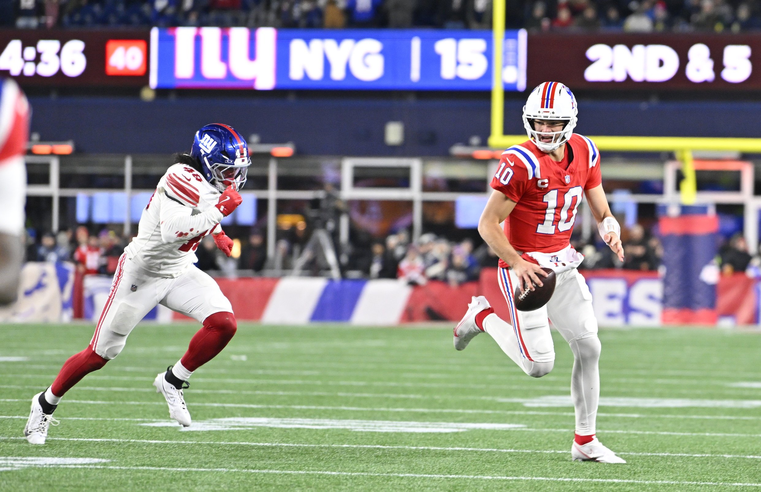 Dec 1, 2025; Foxborough, Massachusetts, USA; New England Patriots quarterback Drake Maye (10) runs the ball against New York Giants linebacker Zaire Barnes (46) during the fourth quarter at Gillette Stadium. Mandatory Credit: Eric Canha-Imagn Images