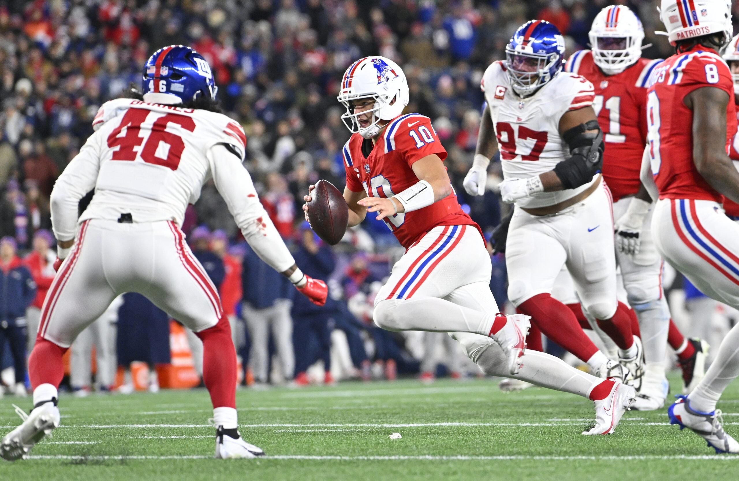Dec 1, 2025; Foxborough, Massachusetts, USA; New England Patriots quarterback Drake Maye (10) runs the ball against New York Giants linebacker Zaire Barnes (46) during the fourth quarter at Gillette Stadium. Mandatory Credit: Eric Canha-Imagn Images