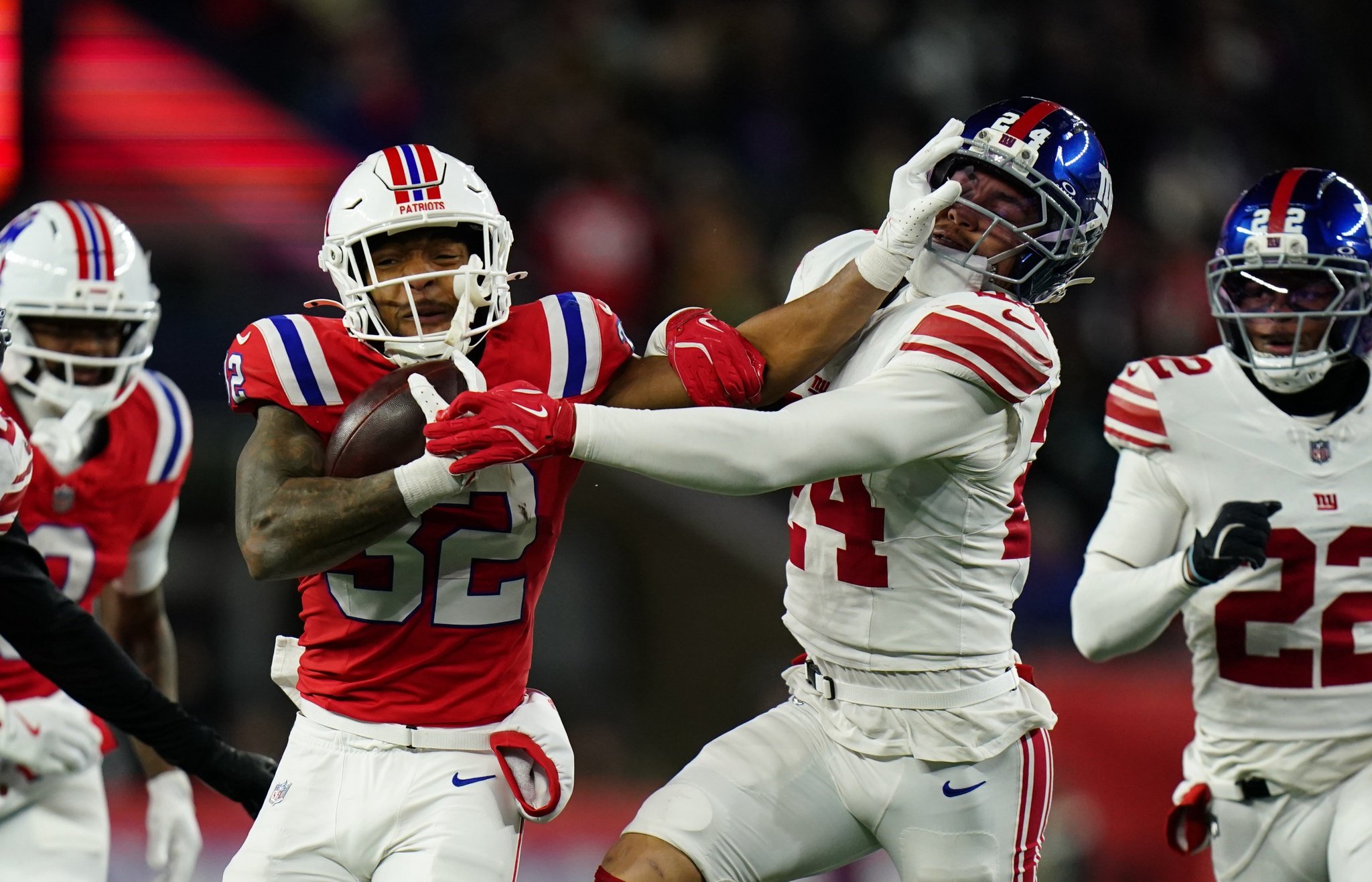 Dec 1, 2025; Foxborough, Massachusetts, USA; New England Patriots running back TreVeyon Henderson (32) runs the ball against New York Giants safety Dane Belton (24) during the fourth quarter at Gillette Stadium. Mandatory Credit: David Butler II-Imagn Images