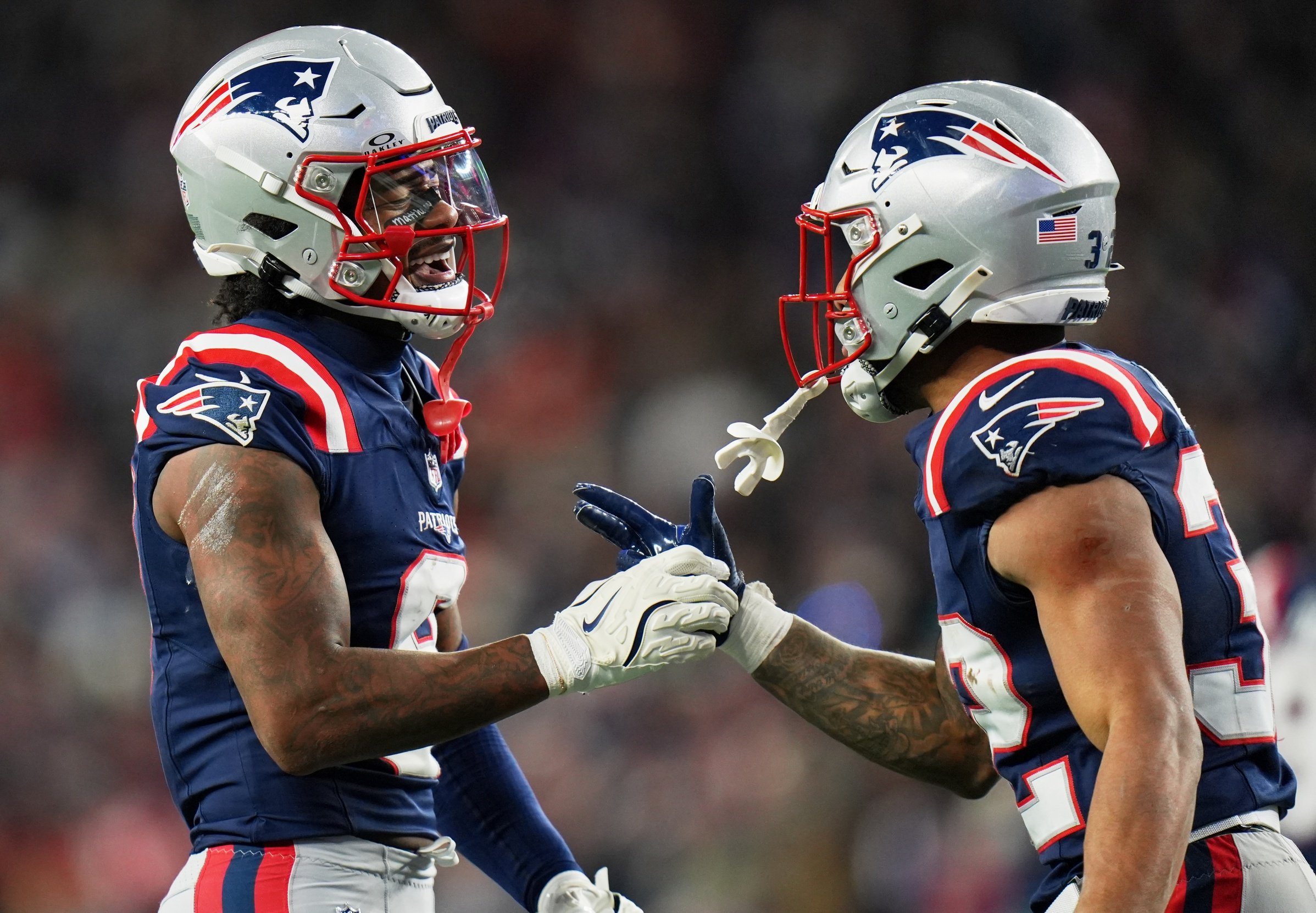 Jan 4, 2026; Foxborough, Massachusetts, USA; New England Patriots wide receiver Stefon Diggs (8) shakes hands with running back TreVeyon Henderson (32) against the Miami Dolphins during the third quarter at Gillette Stadium. Mandatory Credit: David Butler II-Imagn Images