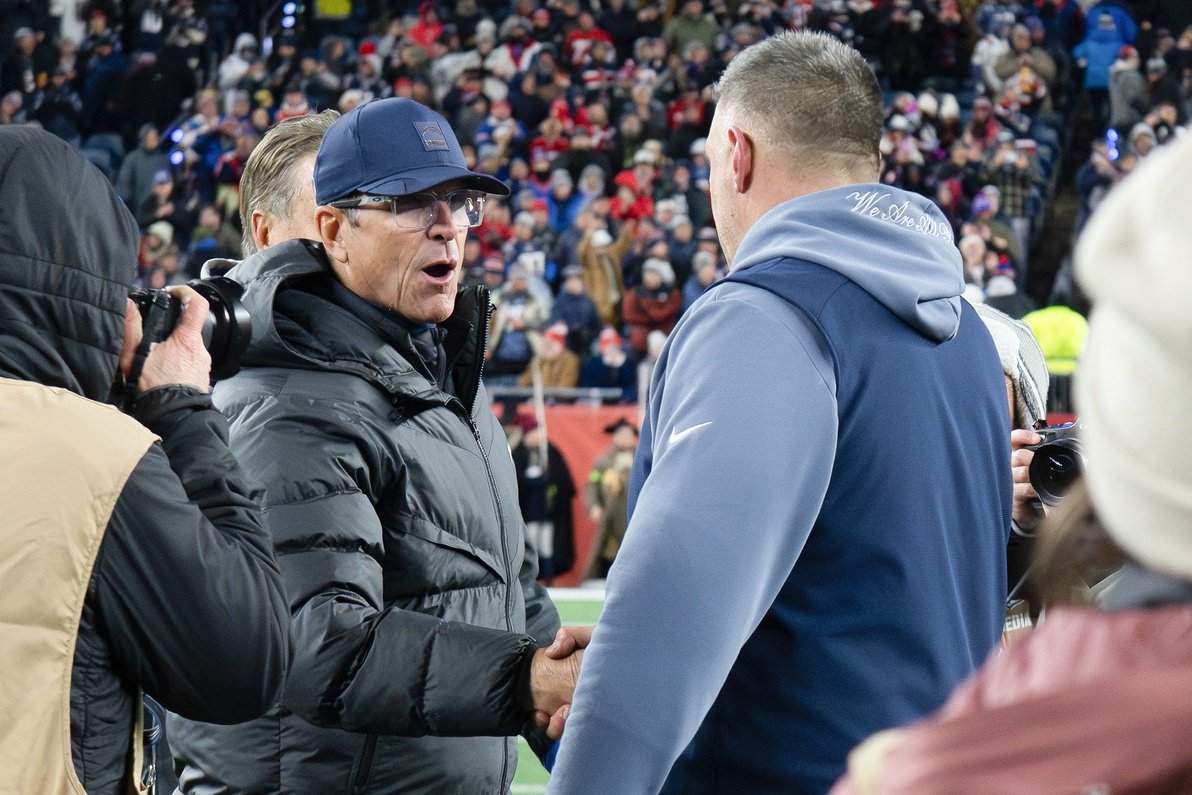 Jan 11, 2026; Foxborough, MA, USA; Los Angeles Chargers head coach Jim Harbaugh  shakes hands with New England Patriots head coach Mike Vrabel  after an AFC Wild Card Round game at Gillette Stadium. Mandatory Credit: Eric Canha-Imagn Images