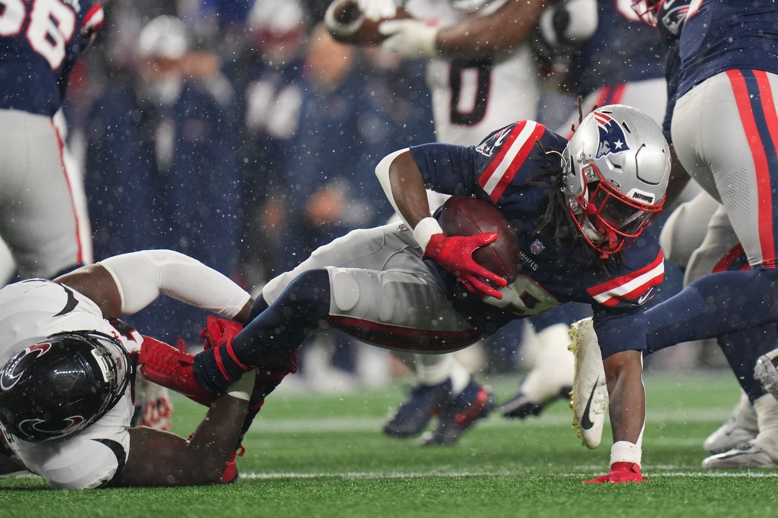Jan 18, 2026; Foxborough, MA, USA; New England Patriots running back Rhamondre Stevenson (38) is brought down by Houston Texans defensive tackle Naquan Jones (91) in the third quarter in an AFC Divisional Round game at Gillette Stadium. Mandatory Credit: David Butler II-Imagn Images